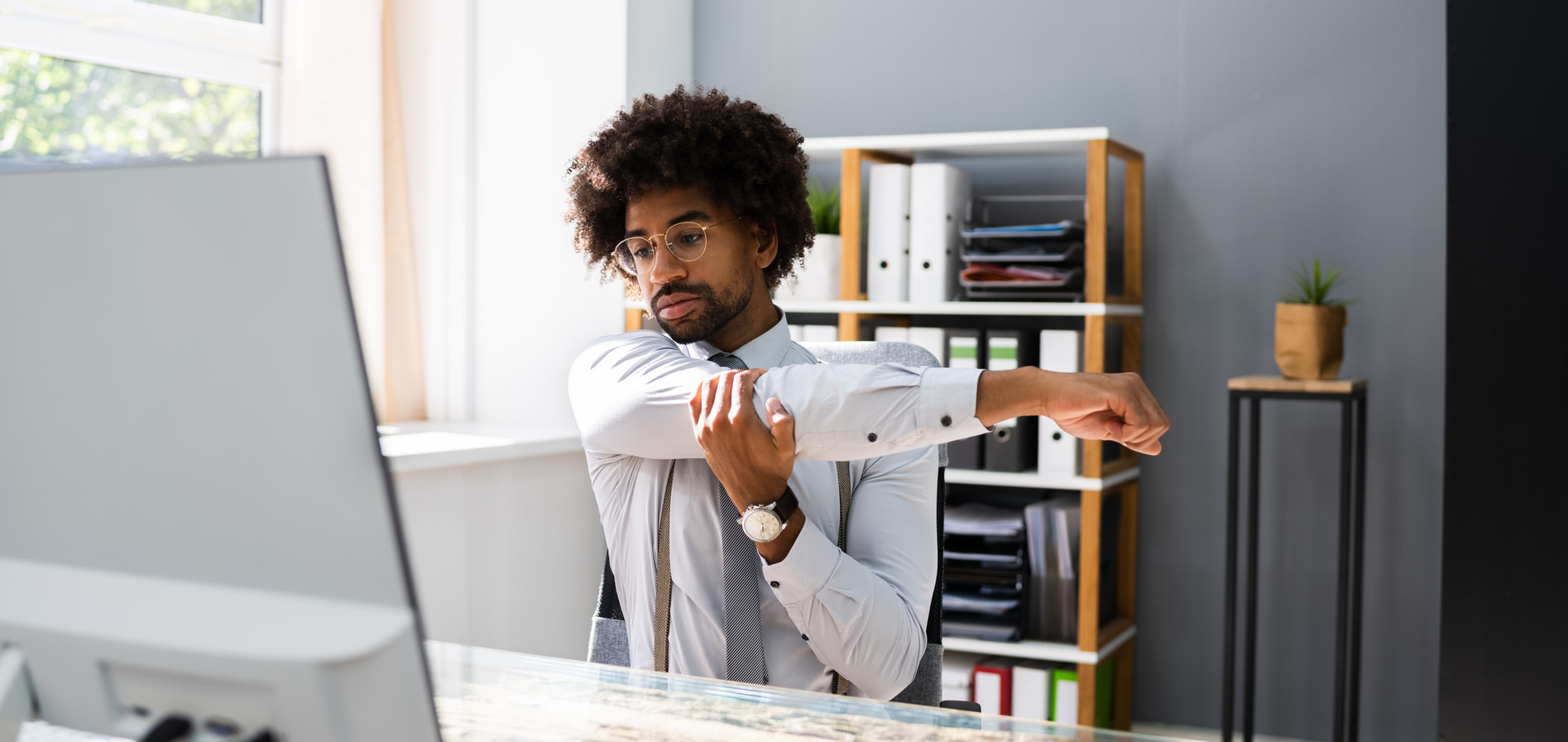 Black Man Stretching At Office Desk