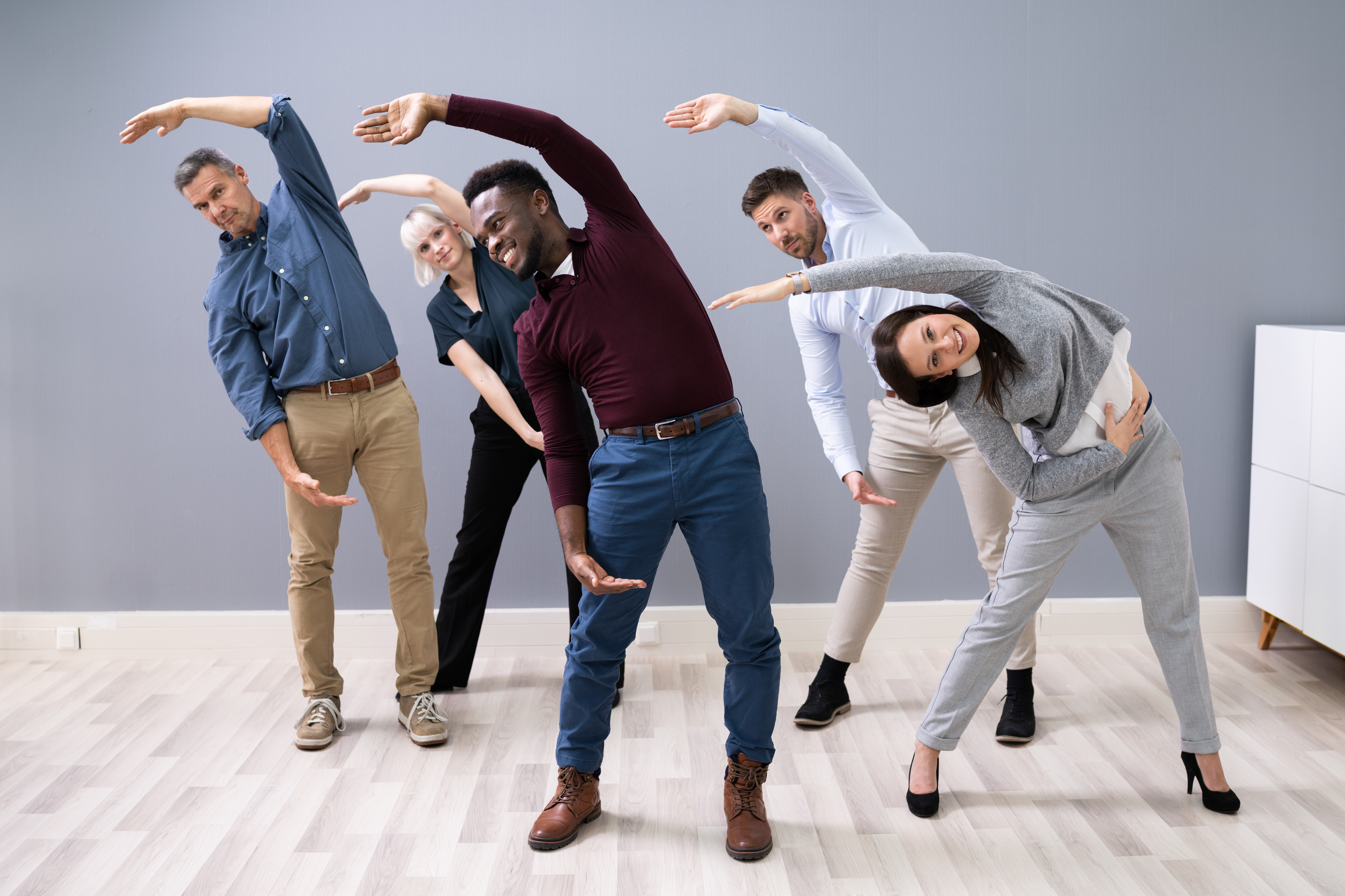 Businesspeople Doing Stretching Exercise At Workplace